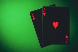 Ace of hearts and ace of diamonds. A pair of aces on a green background, close up shot. Nuts hand a pair of aces to win. Close-up image a pair of aces. 