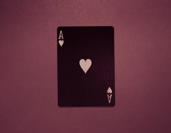 Black poker card ace of hearts close up shot. Ace of hearts on a purple background. 