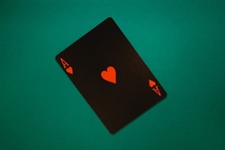 Ace of hearts on a turquoise background. Black poker card ace of hearts close up shot. 
