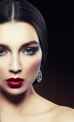 Attractive beauty girl portrait with jewelry and make-up over dark background