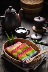 Kue lapis pepe pelangi or Rainbow sticky layer cake is a Indonesian traditional cakes made from rice flour and coconut milk, steamed layer by layer. served on a bamboo tray, blurry background