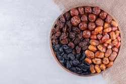 Dates or dattes palm fruit in wooden bowl is snack healthy, Set of various dates in bowl, Different kind of raw date fruit ready to eat, concrete background, Traditional, delicious and healthy ramadan