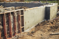 Concrete foundation with reinforcement and metal slab. Construction site, process of house building. Formwork for foundation. New housing construction