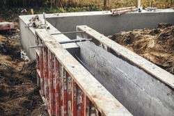 Concrete foundation with reinforcement and metal slab. Formwork for foundation. Construction site, process of house building. New housing construction
