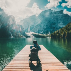 Travel hiker taking photo of Lake Braies (Lago di Braies) in Dolomites Mountains, Italy. Hiking and outdoor adventure lifestyle.