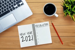 2021 Happy New Year Resolution Goal List - Business office desk with notebook written in handwriting about plan listing of new year goals and resolutions setting. Change and determination concept.