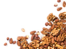 Background of mixed nuts - hazelnuts, walnuts, almonds - with copy space. Isolated one edge. Top view or flat lay