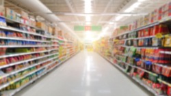 Blurred image of supermarket aisle and shelves.defocused blurry background with bokeh light in store. Business concept.
