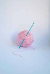 Pink threads with a ball lie on a white background.
