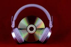 CD and headphones isolated on a red background