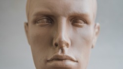 Man's plastic head dummy on a light background close-up
