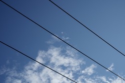 voltage lines (wires) with the blue sky and cloud background