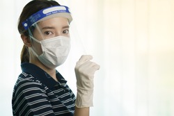 Woman wearing protection medical screen or plastic shield on her face, for corona virus or Covid-19 protection.