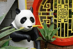 a stuffed panda statue eating bamboo