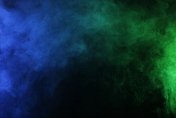 Smoke in blue green light on black background in darkness