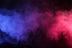 Artificial smoke in red-blue light on black background in darkness