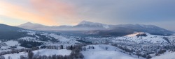 Panorama of winter mountains hills at sunrise