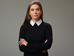 Serious strict teacher woman in black suit with white collar standing with crossed arms, isolated female portrait.