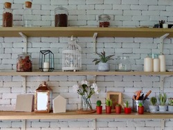 Miscellaneous on the wall shelf. Things on the brick wall shelf. Shelves on a white brick wall. Decorative items on the shelf. Interior design of wall.