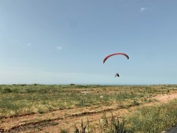 Paraglide landing. Outdoor adrenaline sport paraglide parachute flying close to ground. Summer fun activities.
