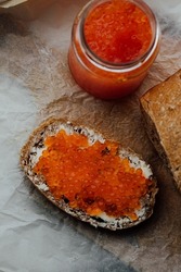 sandwich with red caviar on a wooden texture. bread with red caviar