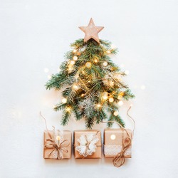 Zero Waste Christmas concept. Christmas tree made of natural fir branches with wooden star and paper lace gift.