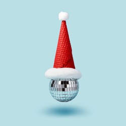 Inverted disco ball ice cream and santa hat waffle cone levitates on blue background. Minimal Christmas party concept.