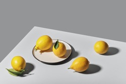Trending colors of 2021. Yellow illuminating lemons on Ultimate gray tablecloth. Isometric view minimal still life.
