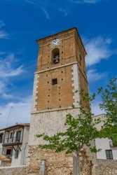 Spanish church tower, capturing Chinchón's religious heritage, intricate clock face and ancient bell in view