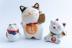 A Maneki-neko or also known as fortune cat in porcelain. Symbolizing luck and wealth, on a white isolated background. Chinese character translate as 