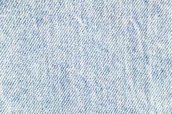 Closeup light blue jeans denim fabric texture background.