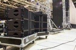Flight cases with line array speakers. Stage, trusses, led screen and sound speakers background. Installation of professional concert equipment.
