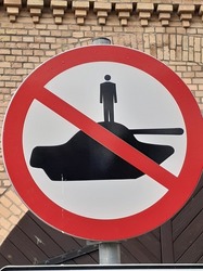 Picture of a road sing that says that standing on tanks is not allowed. 