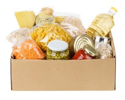 Various canned food, pasta and cereals in a cardboard box. Food donations or food delivery concept. Isolated on white.