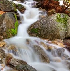 HDR image of a frothy mountain stream through boulders capture with a long exposure