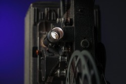 Detail of vintage 8mm film projector with blue background