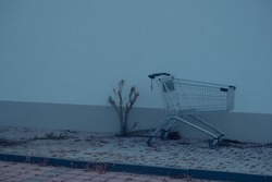 Empty abandoned shopping cart near a wall
