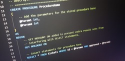 SQL (Structured Query Language) code example to create stored procedures on the computer monitor. Programmer text editor with dark theme.