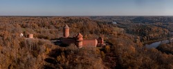 Aerial view of tthe Sigulda city in Latvia during golden autumn. Medieval castle in the middle of the forest.