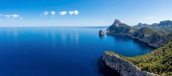 Panoramic view of beautiful Mediterranean seascape. Scenic Rocky cliffs on seaside against sky. Idyllic blue ocean at island in summer.