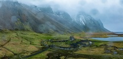 Aerial view of a viking village on a stormy rainy day near Stokksnes under Vestrahorn mountain, Iceland.
