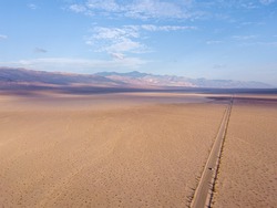Sunset aerial view in the Death Valley. Huge salt lake with an endless road.