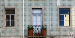 Element of the facade of the house. Old building with a green wall is decorated with Azulejo, Lisbon, Portugal