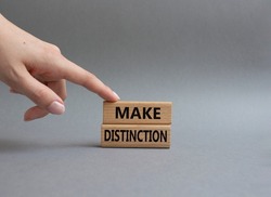 Make distinction symbol. Concept words make distinction on wooden blocks. Beautiful grey background. Business and make distinction concept. Copy space. Conceptual image