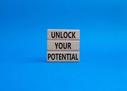Unlock your Potential symbol. Wooden blocks with words Unlock your Potential. Beautiful blue background. Business and Unlock your Potential concept. Copy space.