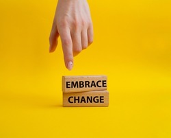 Embrace change symbol. Concept word Embrace change on wooden blocks. Beautiful yellow background. Businessman hand. Business and Embrace change concept. Copy space