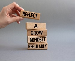 Refclect a grow mindset regularly symbol. Wooden blocks with words Refclect a grow mindset regularly. Businessman hand. Beautiful grey background. Business concept. Copy space.