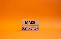 Make distinction symbol. Concept words make distinction on wooden blocks. Beautiful orange background. Business and make distinction concept. Copy space.