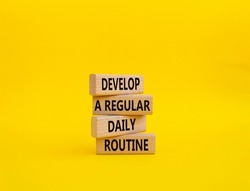 Develop a regular daily routine symbol. Concept words Develop a regular daily routine on wooden blocks. Beautiful yellow background. Business and Develop a regular daily routineconcept. Copy space.
