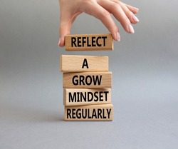 Refclect a grow mindset regularly symbol. Wooden blocks with words Refclect a grow mindset regularly. Businessman hand. Beautiful grey background. Business concept. Copy space.